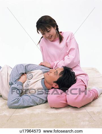 Stock Image - A man resting on his wife's lap. Fotosearch