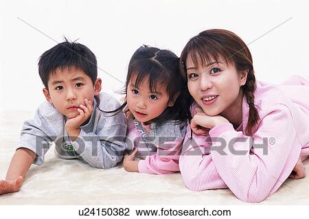 A mother and two children lying on floor View Large Photo Image Stock Image - A mother and two children lying on floor. Fotosearch