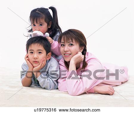 A mother and two children lying on floor View Large Photo Image Stock Photograph - A mother and two children lying on floor. Fotosearch