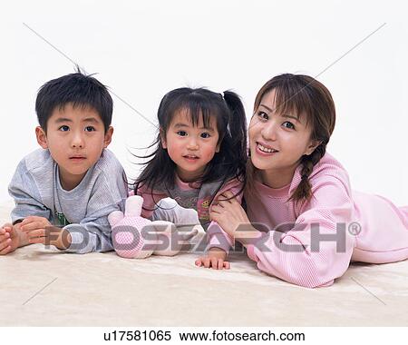 Stock Photography - A mother and two children lying on floor. Fotosearch