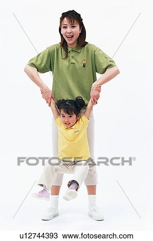 Stock Image - A mother lifting up her daughter. Fotosearch