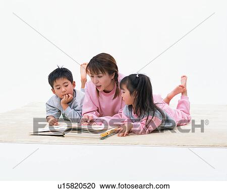 A mother reading a book to her children View Large Photo Image Stock Image - A mother reading a book to her children. Fotosearch