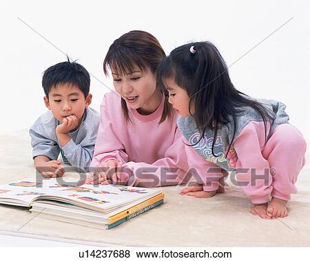 Stock Photo - A mother reading a book to her children. Fotosearch