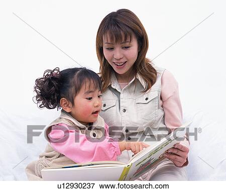 A mother reading a book to her daughter View Large Photo Image Stock Photo - A mother reading a book to her daughter. Fotosearch