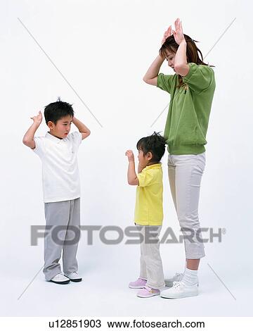 Stock Image - A mother with her two children raising hands while playing. Fotosearch
