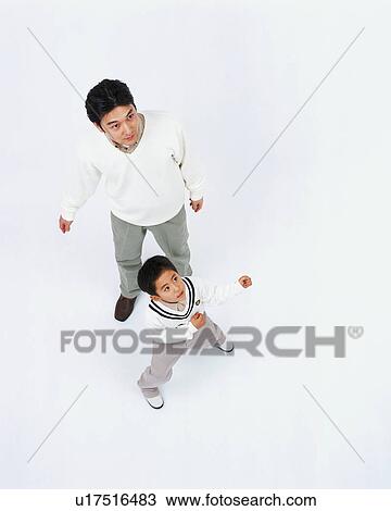 Stock Image - High angle view of a boy posing with his father. Fotosearch