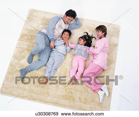 High angle view of a happy family lying on floor View Large Photo Image Stock Photo - High angle view of a happy family lying on floor. Fotosearch