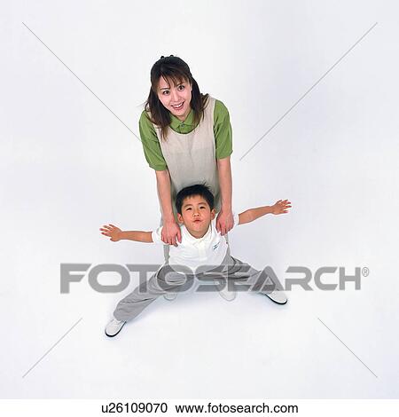 Stock Image - High angle view of a small boy stretching his arms out with his mother. Fotosearch