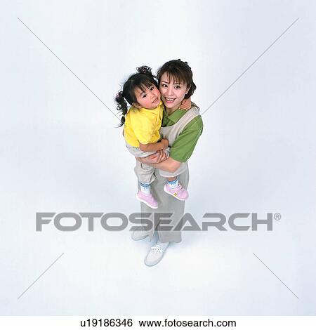Stock Photograph - High angle view of a woman holding her daughter. Fotosearch