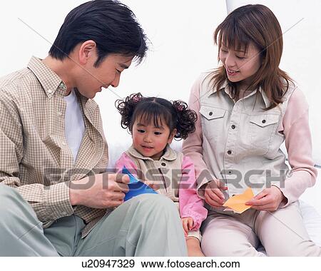 Stock Photo - Parents playing with their daughter . Fotosearch