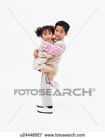 A boy carrying his younger sister View Large Photo Image Stock Photo - A boy carrying his younger sister. Fotosearch