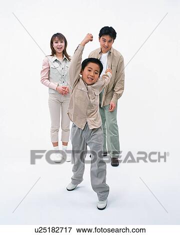 Stock Photo - A boy swinging his hands while his parents stands behind. Fotosearch