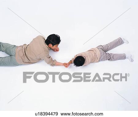Stock Photo - A father and a son arm wrestling. Fotosearch