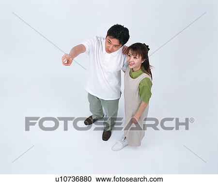 Stock Image - A man pointing out at a direction while his wife looks on. Fotosearch