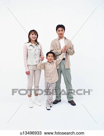 Stock Image - A small boy looking at camera with his parents. Fotosearch