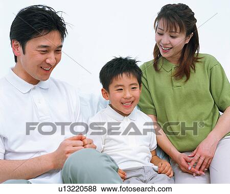 A small boy smiling along with his father and mother View Large Photo Image Stock Photo - A small boy smiling along with his father and mother. Fotosearch