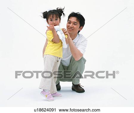 A small girl holding her toy and her father looking on View Large Photo Image Stock Image - A small girl holding her toy and her father looking on. Fotosearch