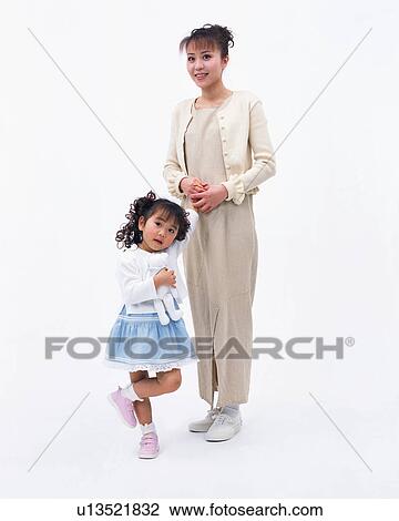 A small girl holding her toy with her mother standing next to her View Large Photo Image Stock Image - A small girl holding her toy with her mother standing next to her. Fotosearch