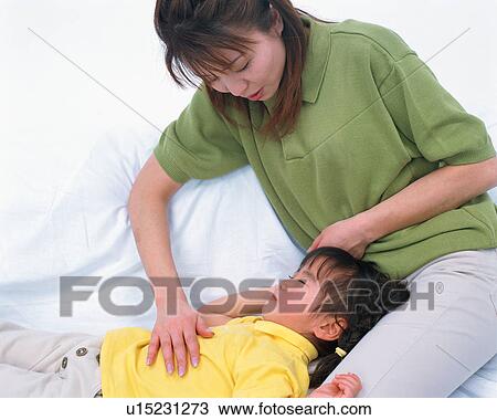 Stock Image - A small girl sleeping and mother watching. Fotosearch