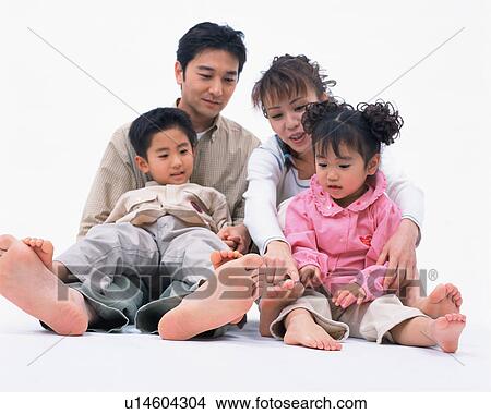 A woman showing her daughter barefoot while her husband and son look on View Large Photo Image Picture - A woman showing her daughter barefoot while her husband and son look on. Fotosearch