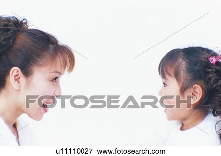Stock Photo - Close up of a woman and her daughter having an eye contact. Fotosearch
