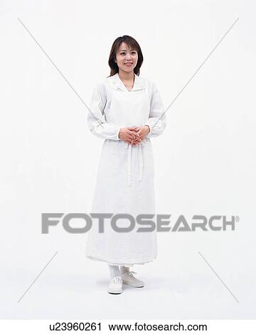 Stock Image - Front view of a pretty woman wearing an apron. Fotosearch