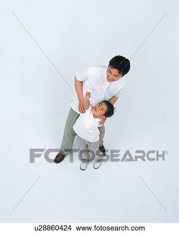 High angle view of a small boy stretching his hand as his father looks on View Large Photo Image Picture - High angle view of a small boy stretching his hand as his father looks on. Fotosearch