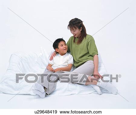 Mother and her son sitting on sofa View Large Photo Image Stock Photo - Mother and her son sitting on sofa. Fotosearch