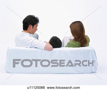 Rear view of a son sitting on couch along with his parents View Large Photo Image Stock Photograph - Rear view of a son sitting on couch along with his parents. Fotosearch