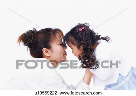 Side view of a woman and her daughter having an eye contact View Large Photo Image Stock Image - Side view of a woman and her daughter having an eye contact. Fotosearch