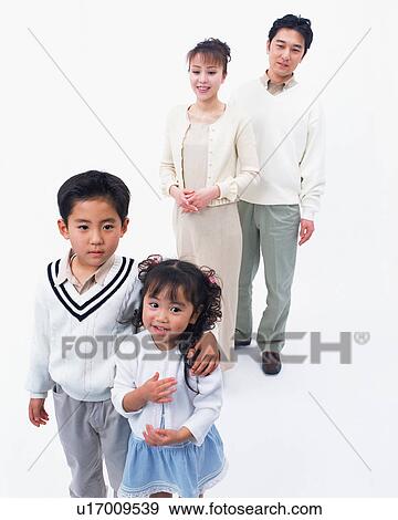 Stock Photo - Two children posing in front of camera with their parents in the background. Fotosearch