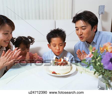 A boy blowing out candles on birthday cake View Large Photo Image Stock Image - A boy blowing out candles on birthday cake. Fotosearch