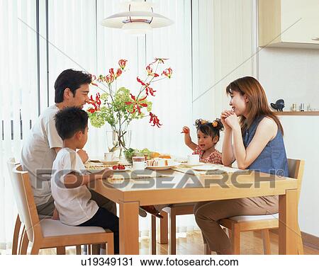 Stock Image - A family at dinning table. Fotosearch