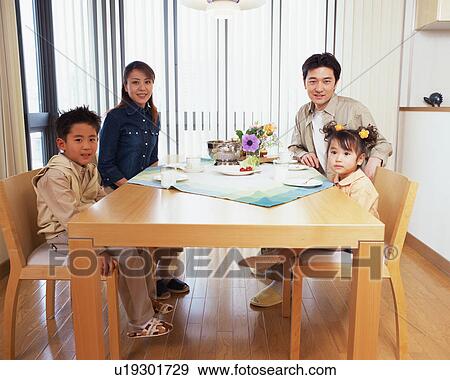 A family at dinning table View Large Photo Image Stock Photo - A family at dinning table. Fotosearch