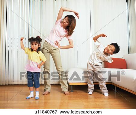 Stock Photo - A family stretching in living room. Fotosearch