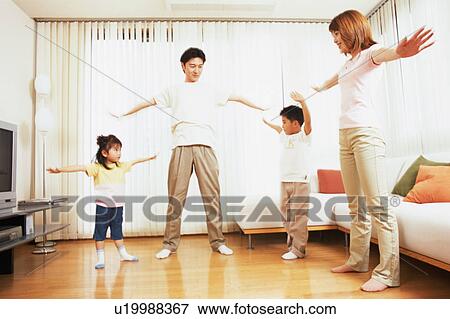 Stock Photo - A family stretching in living room. Fotosearch