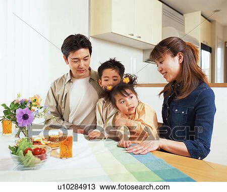A happy family sitting at dining table View Large Photo Image Stock Image - A happy family sitting at dining table. Fotosearch