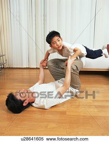 A man heaving his son with his legs View Large Photo Image Stock Photography - A man heaving his son with his legs. Fotosearch