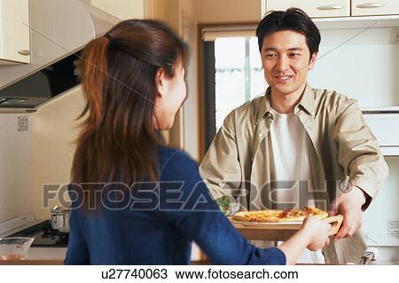 A man helping his wife to serve meal View Large Photo Image Stock Image - A man helping his wife to serve meal. Fotosearch