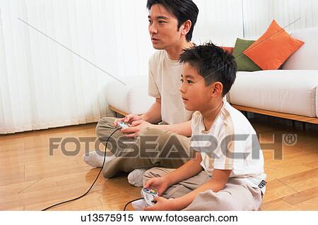 A man playing video game with his son View Large Photo Image Stock Photography - A man playing video game with his son. Fotosearch