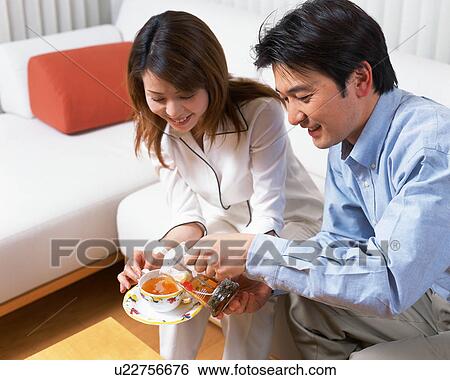 A man pouring tea in a cup held by his wife View Large Photo Image Stock Photograph - A man pouring tea in a cup held by his wife. Fotosearch