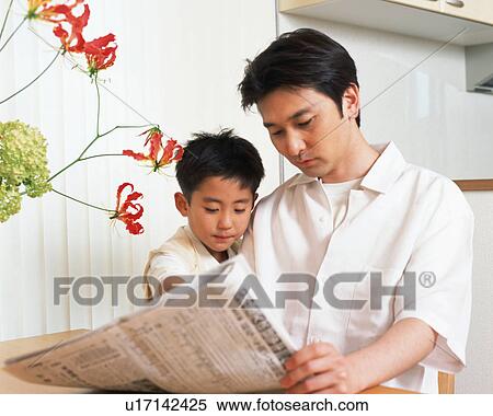 Stock Photography - A man with his son reading newspaper. Fotosearch