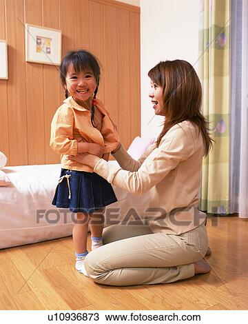 A mother dresses her small daughter View Large Photo Image Stock Image - A mother dresses her small daughter. Fotosearch