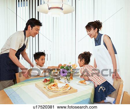 A small boy feeding his younger sister as their parents look on View Large Photo Image Stock Image - A small boy feeding his younger sister as their parents look on. Fotosearch
