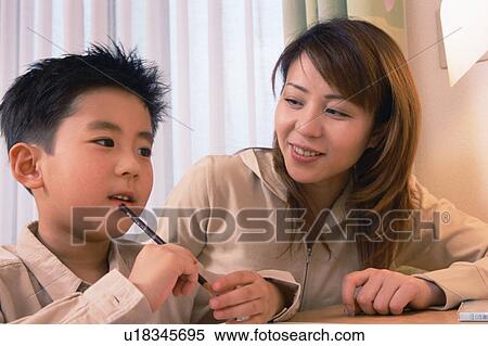 Stock Photography - A small boy thinking with a pencil in his hand. Fotosearch