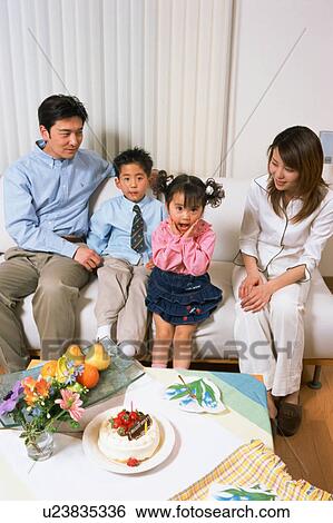 A small girl looking at camera with her family View Large Photo Image Stock Photograph - A small girl looking at camera with her family. Fotosearch