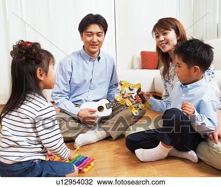 A small girl playing xylophone while family members look at her View Large Photo Image Stock Image - A small girl playing xylophone while family members look at her. Fotosearch