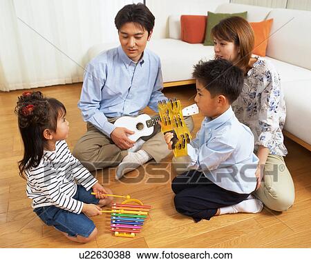 A small girl playing xylophone while family members look at her View Large Photo Image Stock Photo - A small girl playing xylophone while family members look at her. Fotosearch