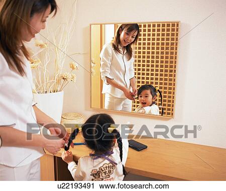 Stock Image - A small girl pointing out at mirror. Fotosearch