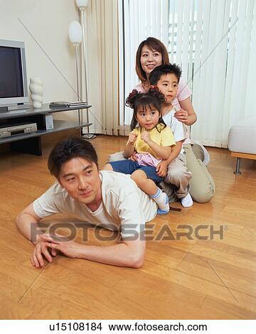 A woman along with her two children sitting on her husband's back View Large Photo Image Picture - A woman along with her two children sitting on her husband's back. Fotosearch